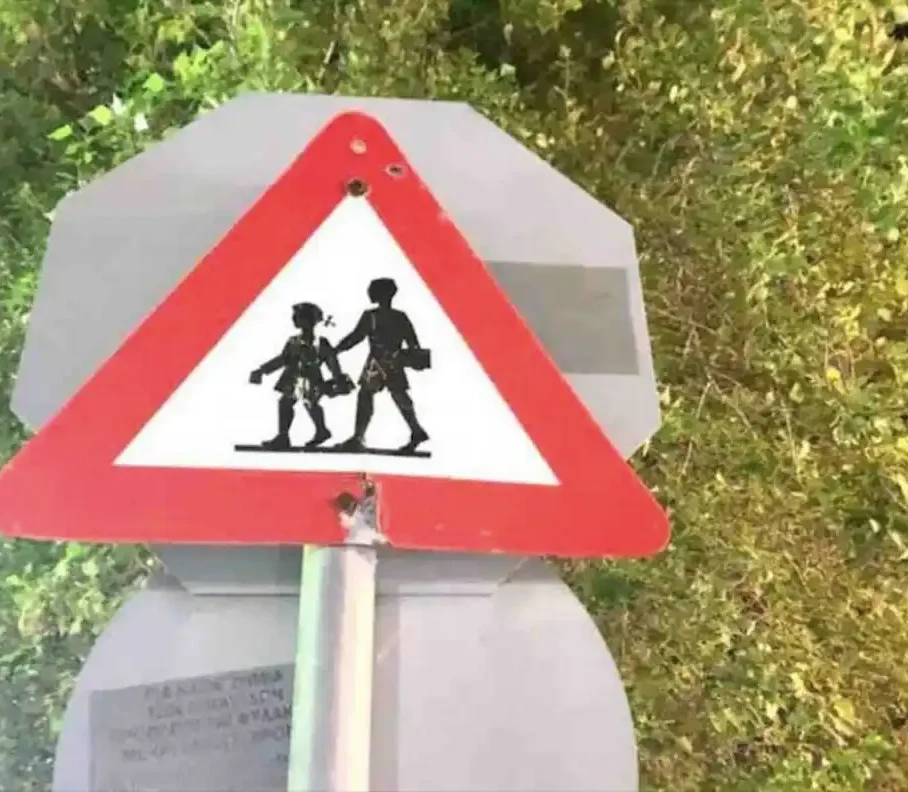 Πινακίδα σχολικής ζώνης μπροστά από δέντρο τη νύχτα