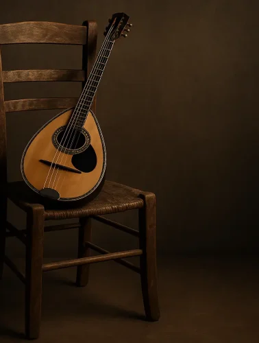 Μπουζούκι τοποθετημένο πάνω σε μια παλιά ξύλινη καρέκλα, με ζεστό φωτισμό και σκούρο φόντο.