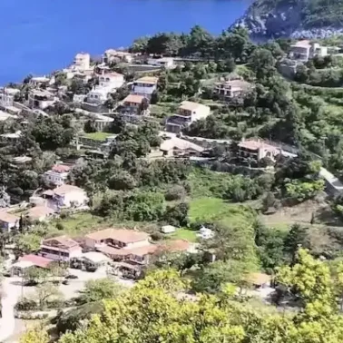 Πανοραμική θέα της Αγίας Σοφίας στην Εύβοια, με καταπράσινες πλαγιές, σπίτια με κεραμοσκεπές και στο βάθος το ρέμα που κατηφορίζει προς τον Λιμνιώνα. Ήπιο απογευματινό φως και καθαρός ουρανός.