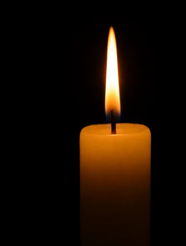 Ένα κερί καίει σιωπηλά, συμβολίζοντας την προσευχή και τη θεϊκή προστασία στη γιορτή των Ταξιαρχών.