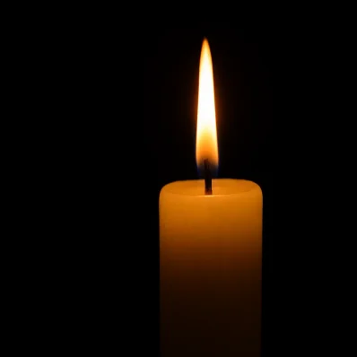 Ένα κερί καίει σιωπηλά, συμβολίζοντας την προσευχή και τη θεϊκή προστασία στη γιορτή των Ταξιαρχών.